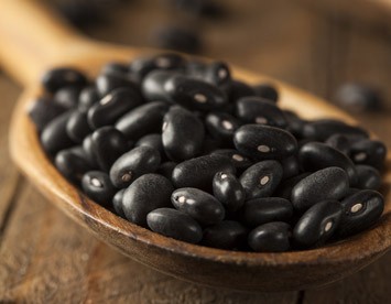 Black beans in a wooden spoon